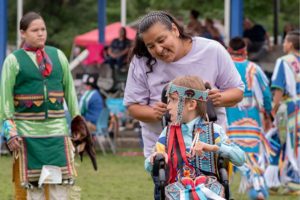 Photo of a young child with developmental disabilities at a Native American event